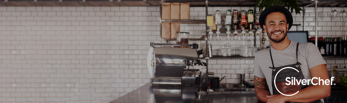 A smiling cafe owner behind his counter, with the SilverChef logo